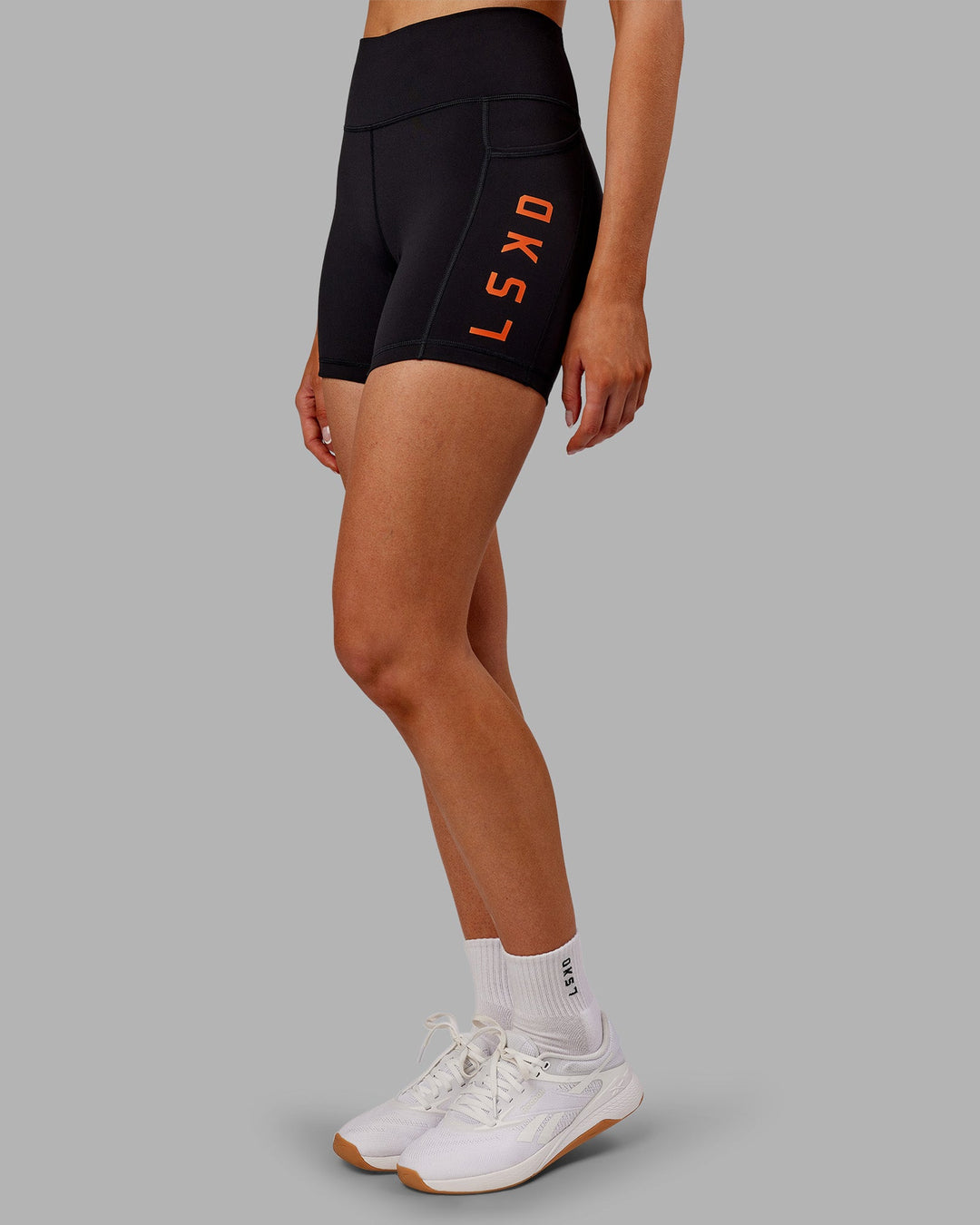 Woman wearing Rep Ultra High-Rise 4" Short Pockets - Black-Ultra Orange | Model:Ella | Size:S