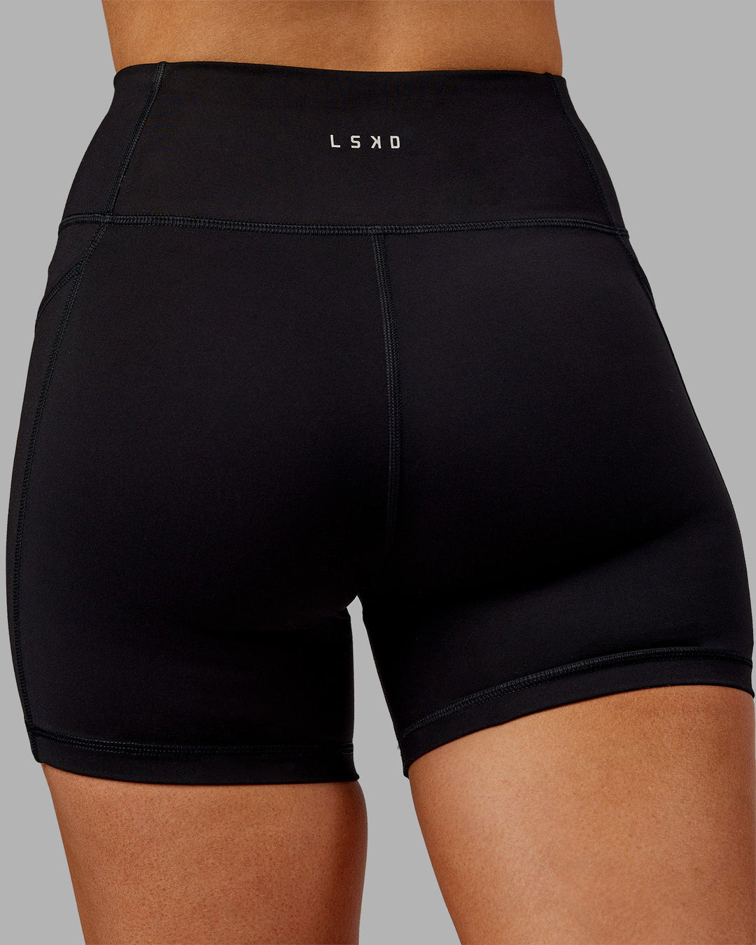 Woman wearing Rep Ultra High-Rise 4" Short Pockets - Black-Ultra Orange | Model:Ella | Size:S