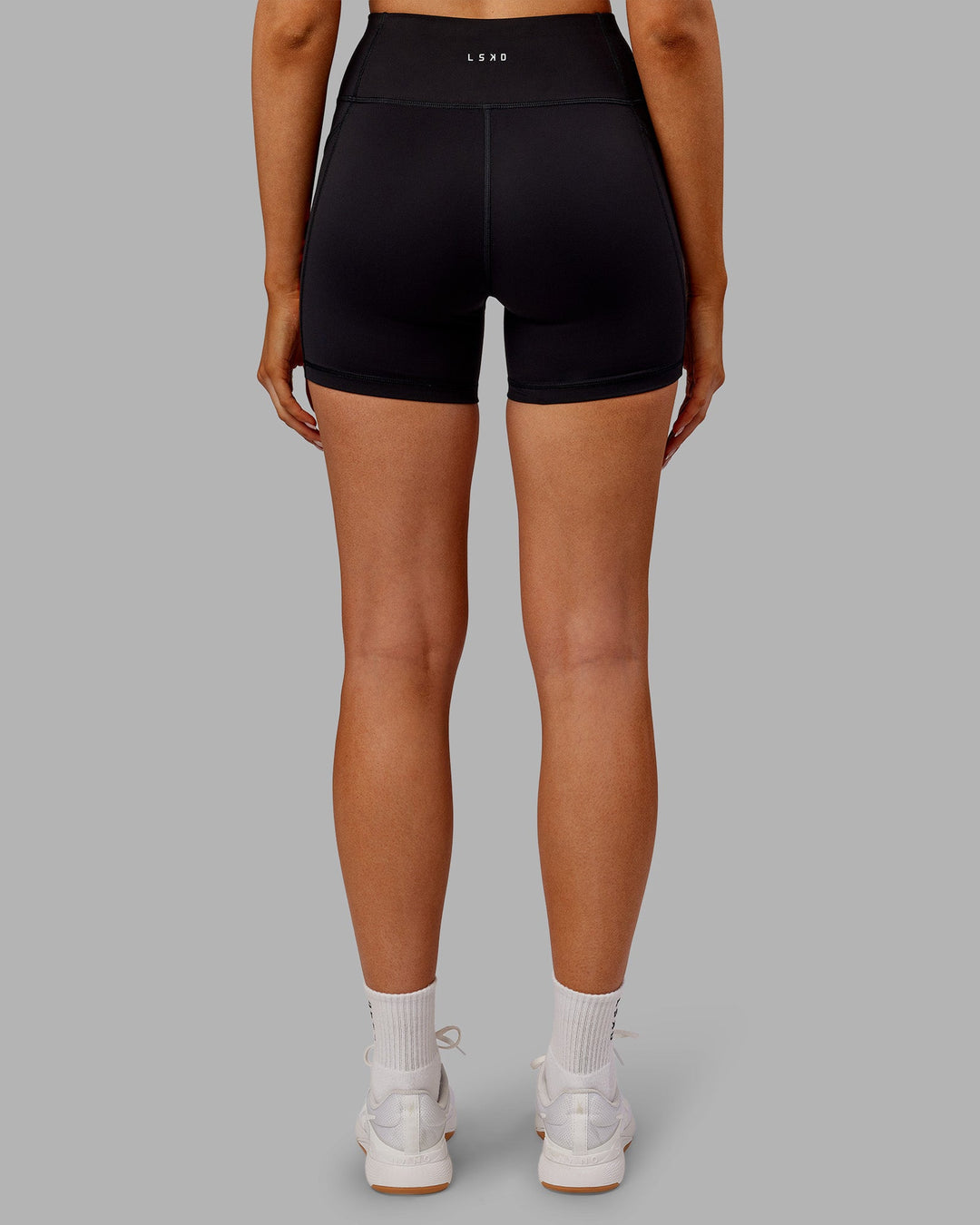 Woman wearing Rep Ultra High-Rise 4" Short Pockets - Black-Ultra Orange | Model:Ella | Size:S