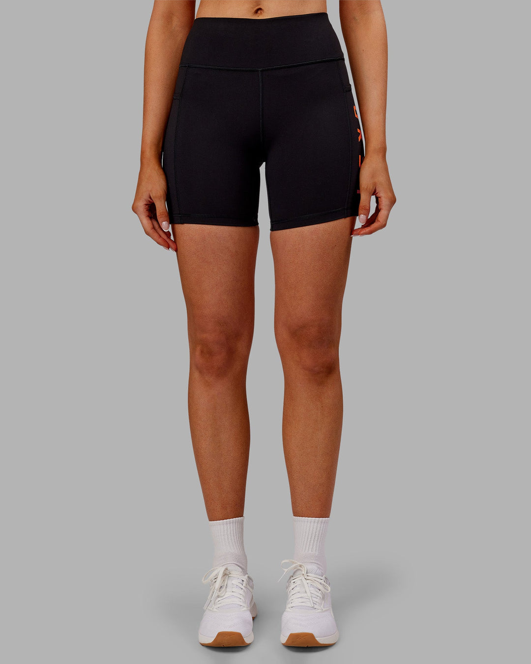 Woman wearing Rep Ultra High-Rise 6" Short Pockets - Black-Ultra Orange | Model:Ella | Size:S