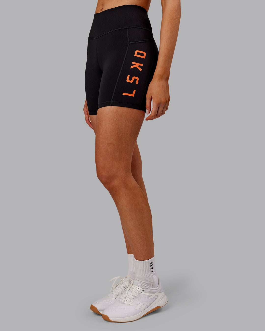 Woman wearing Rep Ultra High-Rise 6" Short Pockets - Black-Ultra Orange | Model:Ella | Size:S