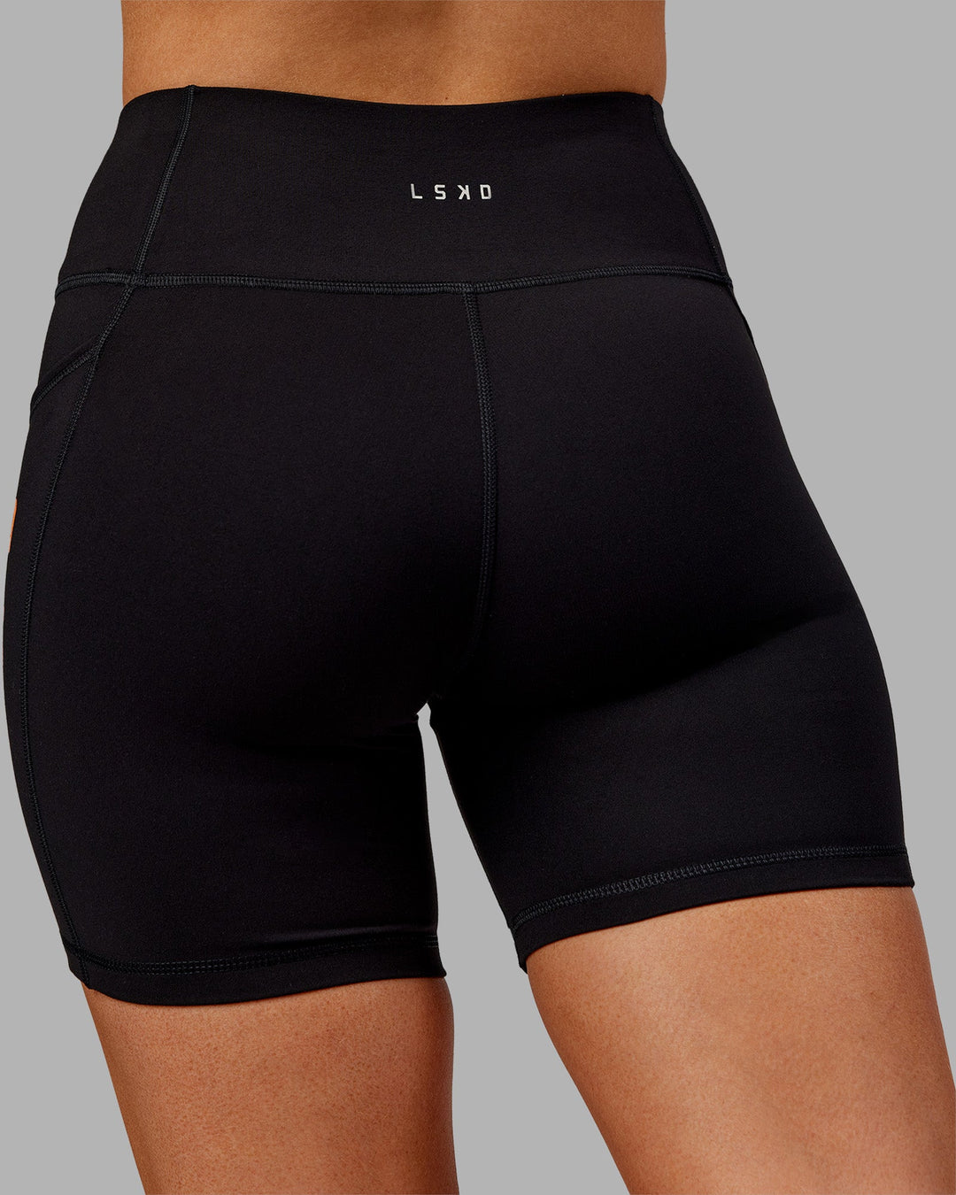 Woman wearing Rep Ultra High-Rise 6" Short Pockets - Black-Ultra Orange | Model:Ella | Size:S