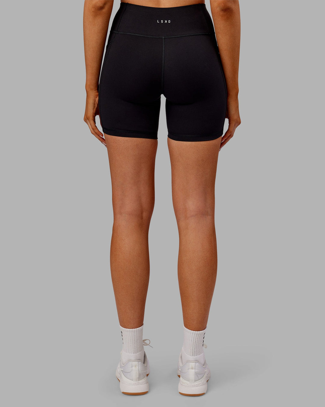 Woman wearing Rep Ultra High-Rise 6" Short Pockets - Black-Ultra Orange | Model:Ella | Size:S