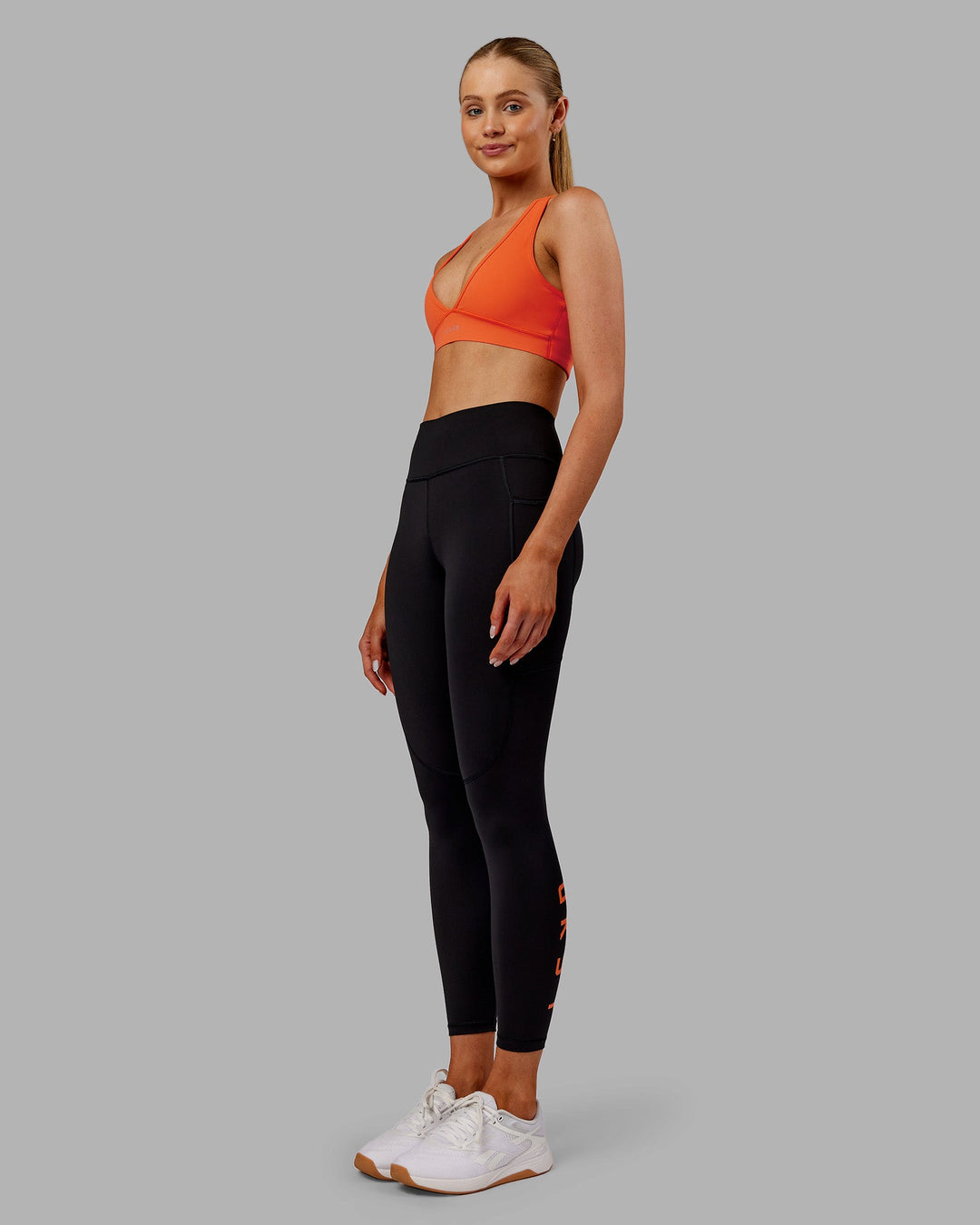 Woman wearing Rep Ultra High-Rise 7/8 Legging Pockets - Black-Ultra Orange | Model:Ella | Size:S
