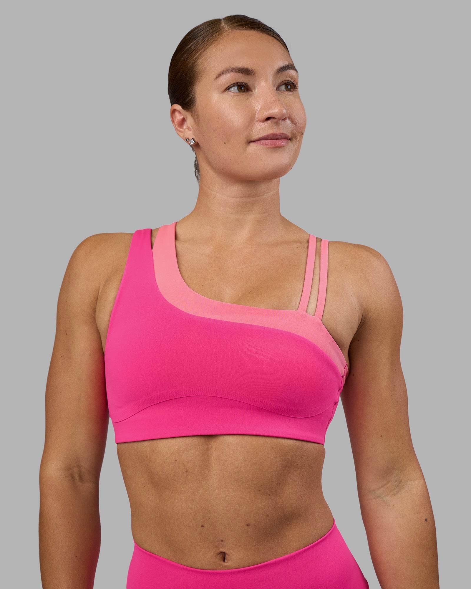 Woman wearing Thrive Asymmetric Sports Bra - Ultra Pink-Candy Pink | Model:Hannah | Size:S