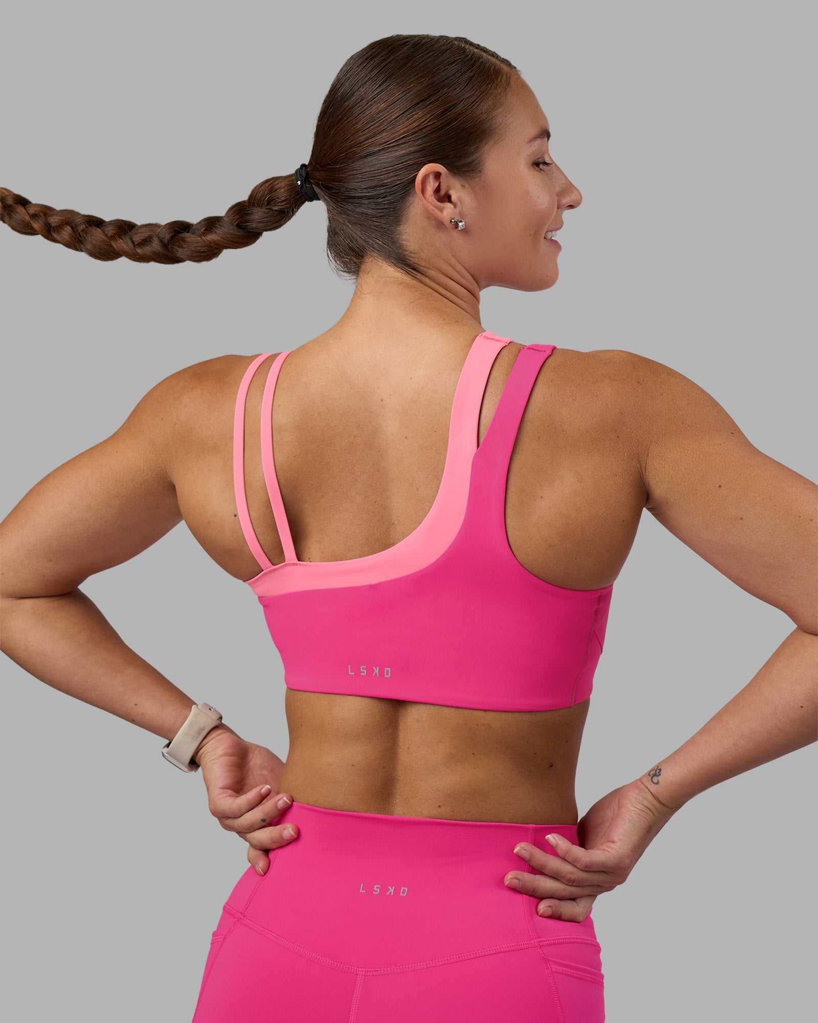 Woman wearing Thrive Asymmetric Sports Bra - Ultra Pink-Candy Pink | Model:Hannah | Size:S