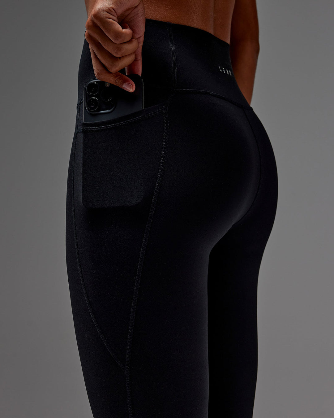 Woman wearing Fusion Ultra High-Rise 3/4 Legging Pockets - Black | Model:Txai | Size:XS