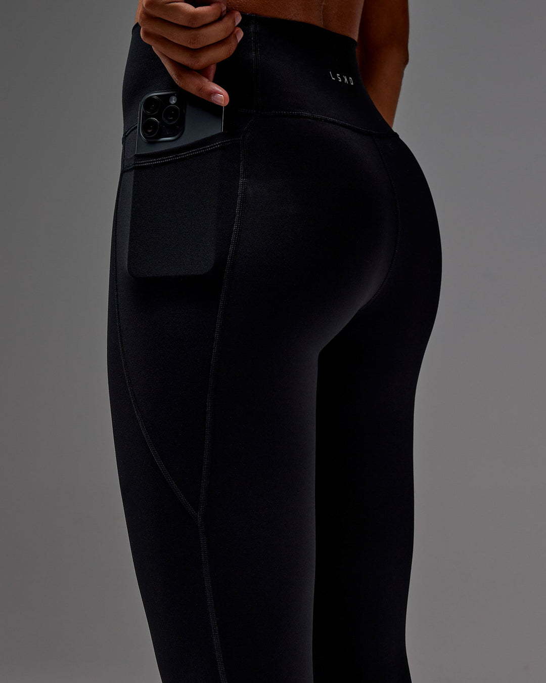 Woman wearing Fusion Ultra High-Rise 7/8 Legging Pockets - Black | Model:Txai | Size:XS