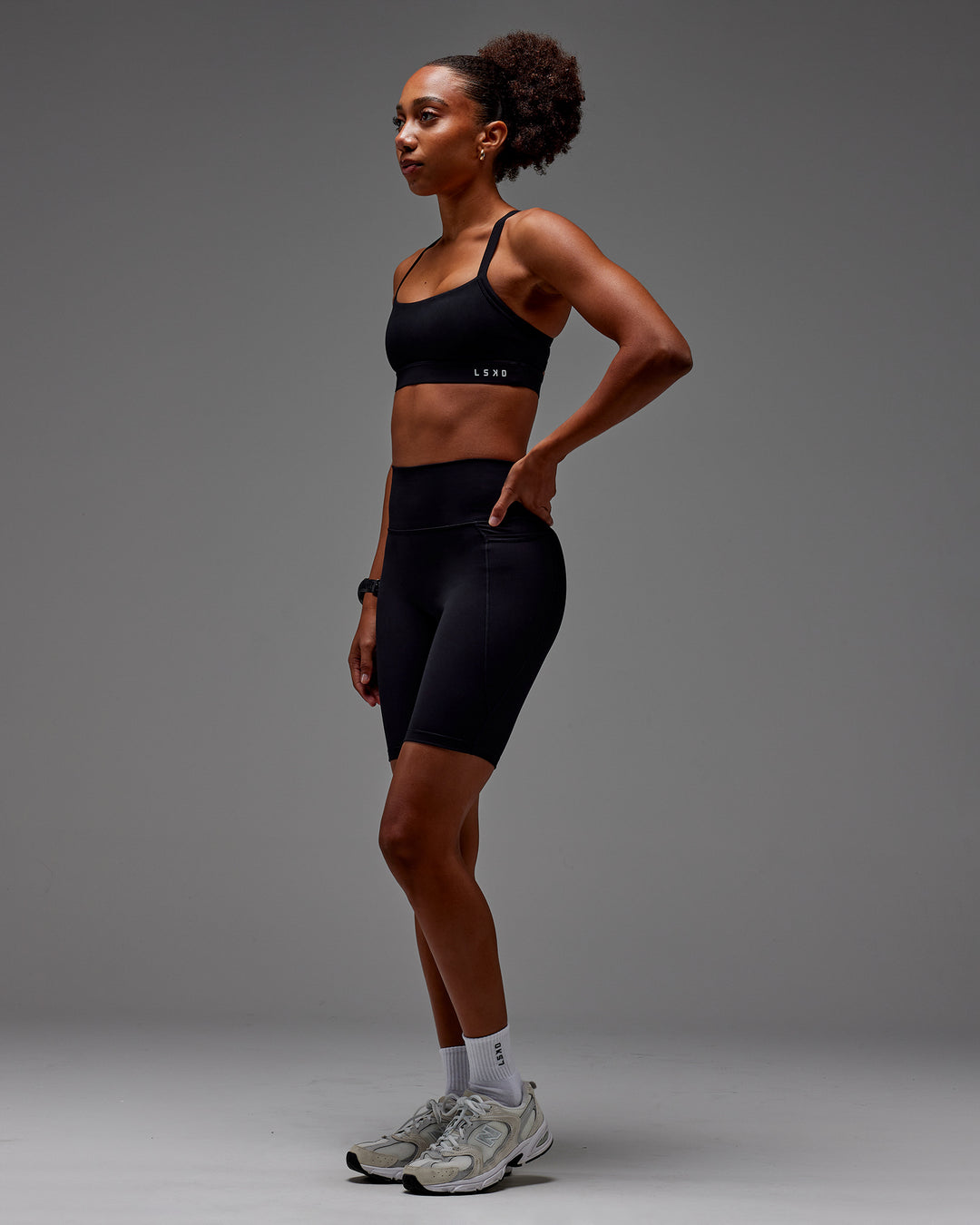 Woman wearing Fusion Ultra High-Rise 9" Short Pockets - Black | Model:Txai | Size:XS