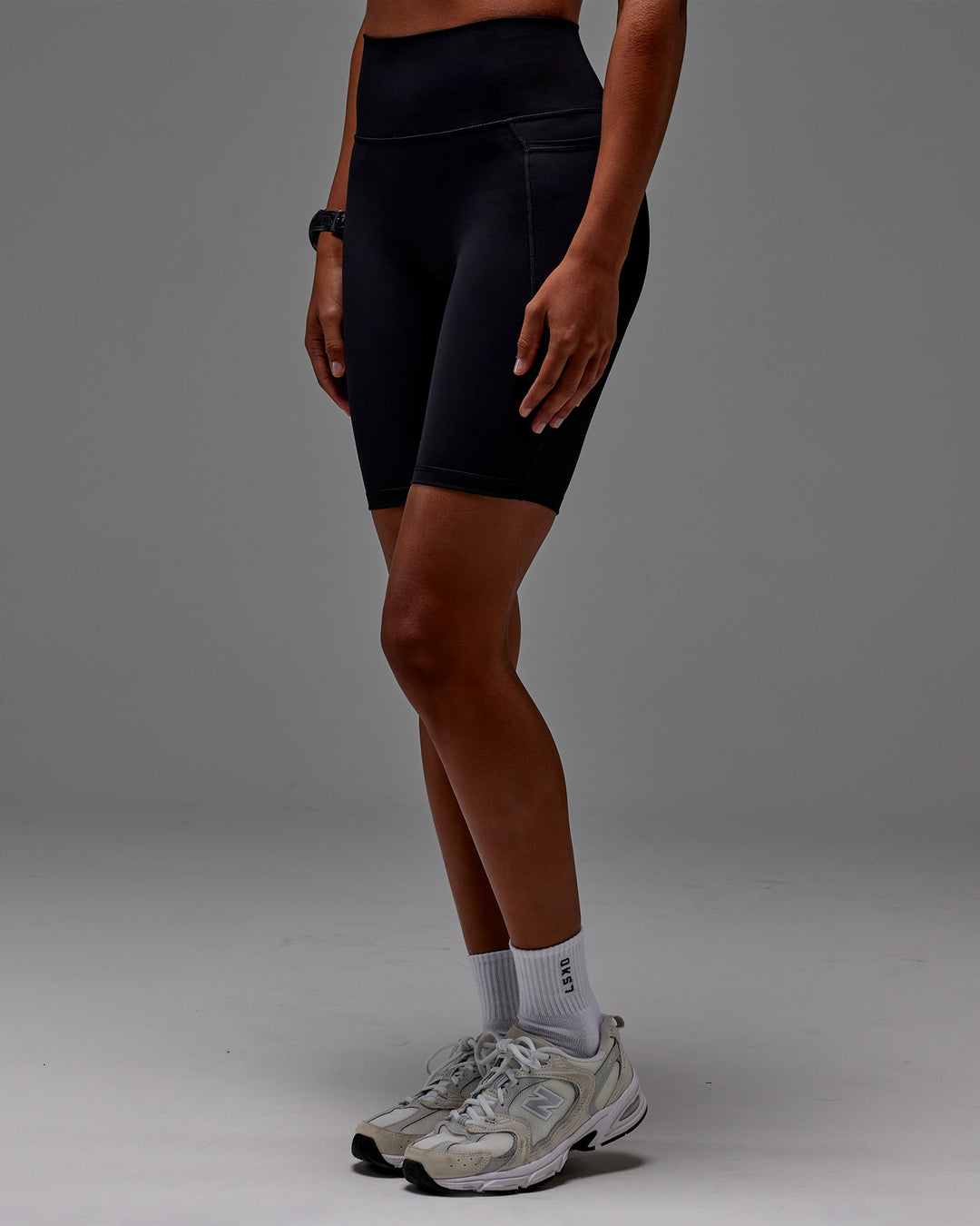 Woman wearing Fusion Ultra High-Rise 9" Short Pockets - Black | Model:Txai | Size:XS