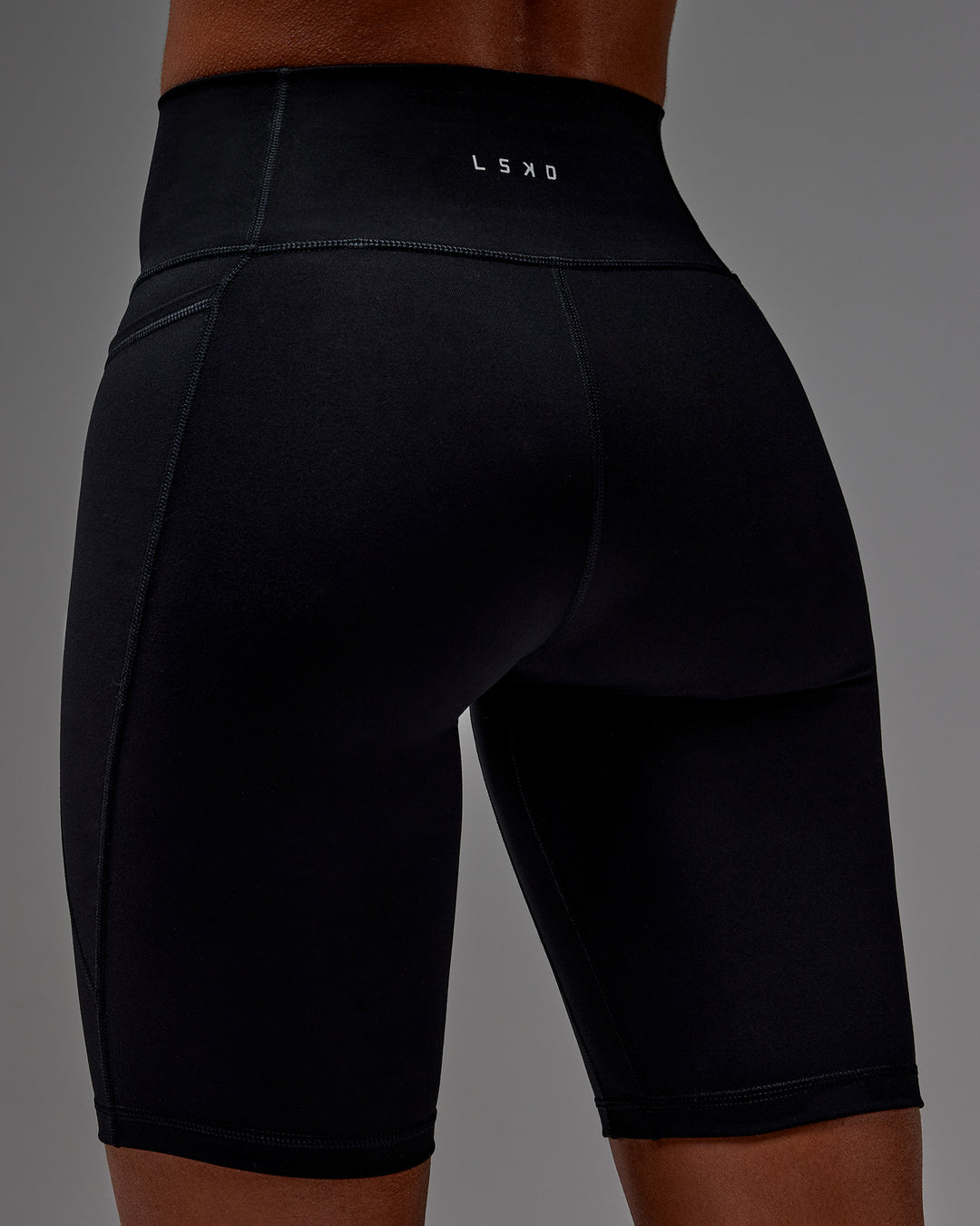 Woman wearing Fusion Ultra High-Rise 9" Short Pockets - Black | Model:Txai | Size:XS