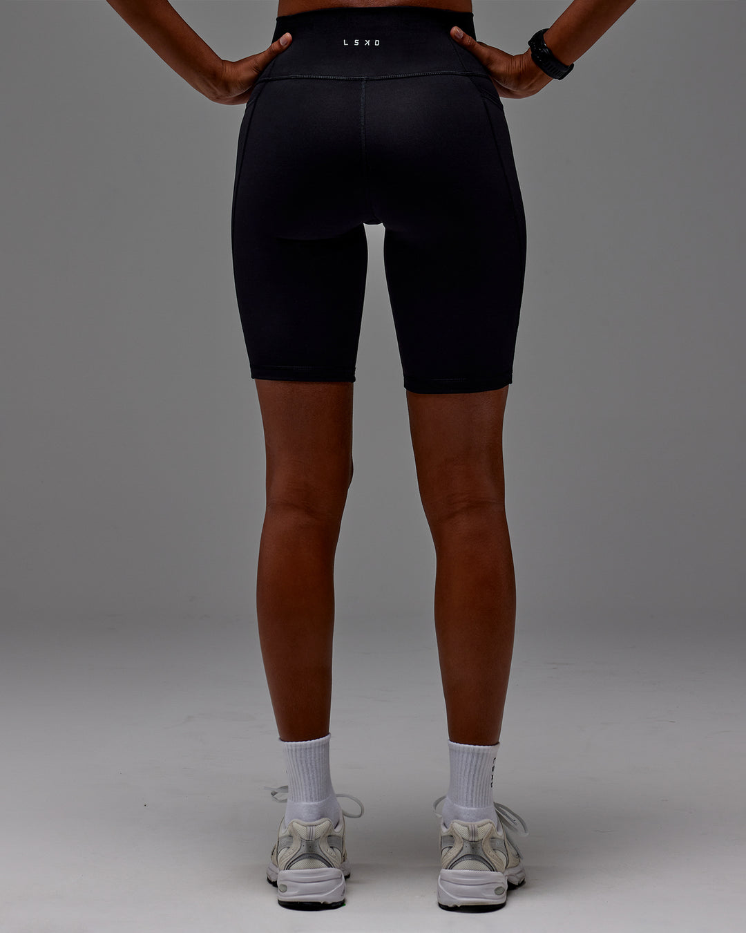 Woman wearing Fusion Ultra High-Rise 9" Short Pockets - Black | Model:Txai | Size:XS