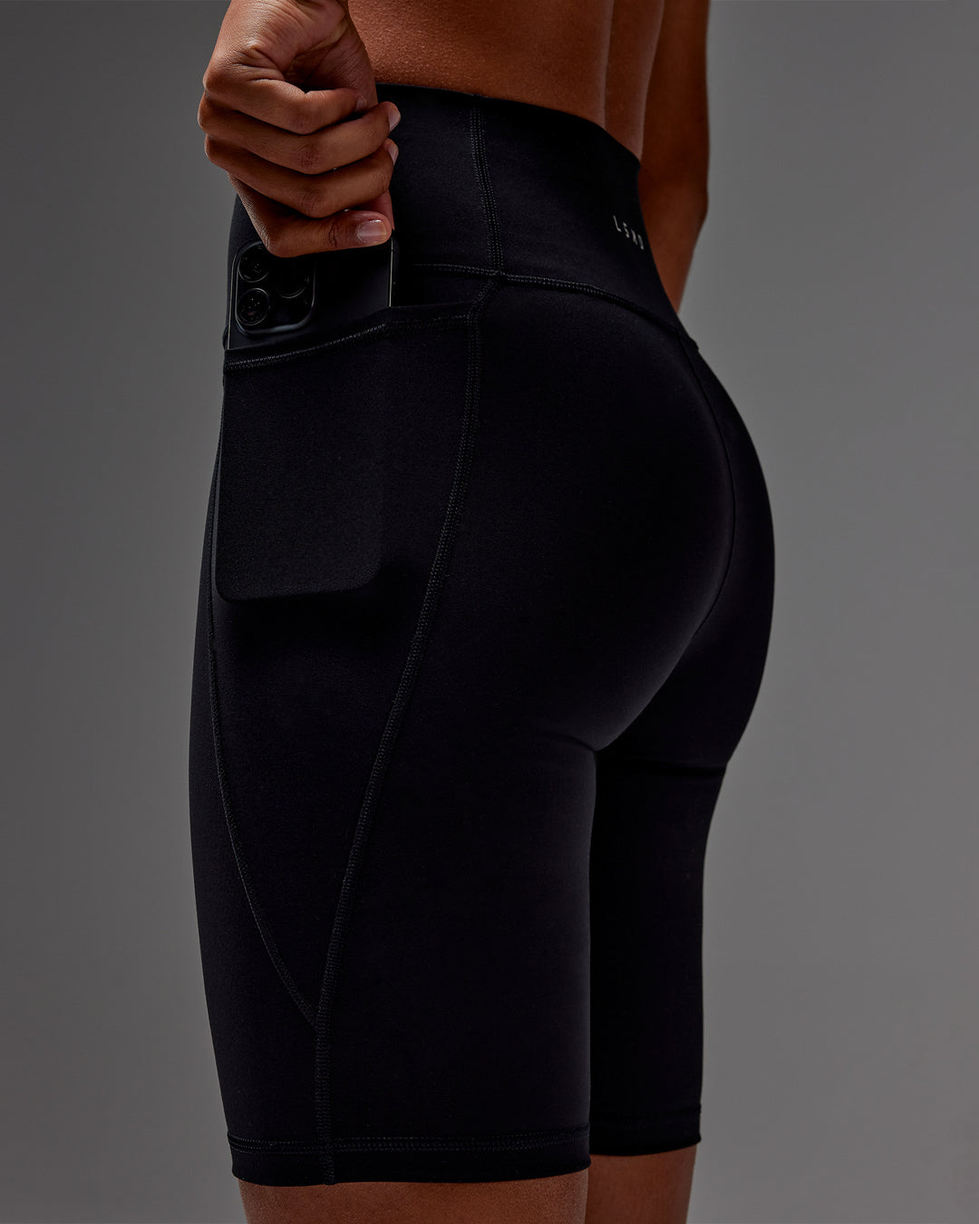 Woman wearing Fusion Ultra High-Rise 9" Short Pockets - Black | Model:Txai | Size:XS