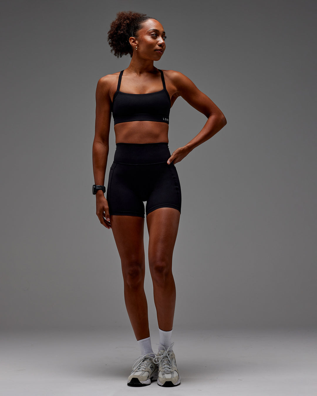 Woman wearing Fusion Ultra High-Rise 6" Short Pockets - Black | Model:Txai | Size:XS