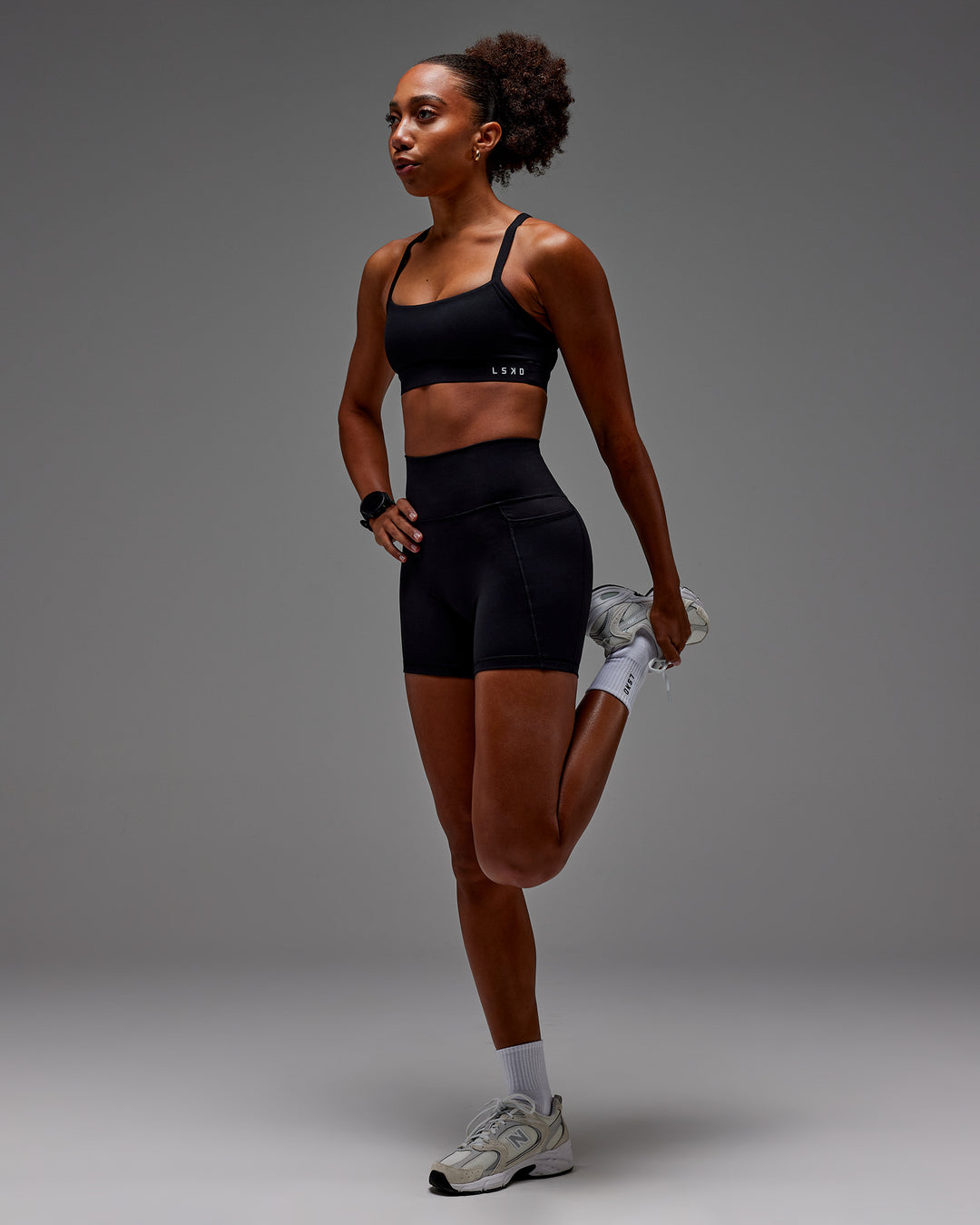 Woman wearing Fusion Ultra High-Rise 6" Short Pockets - Black | Model:Txai | Size:XS