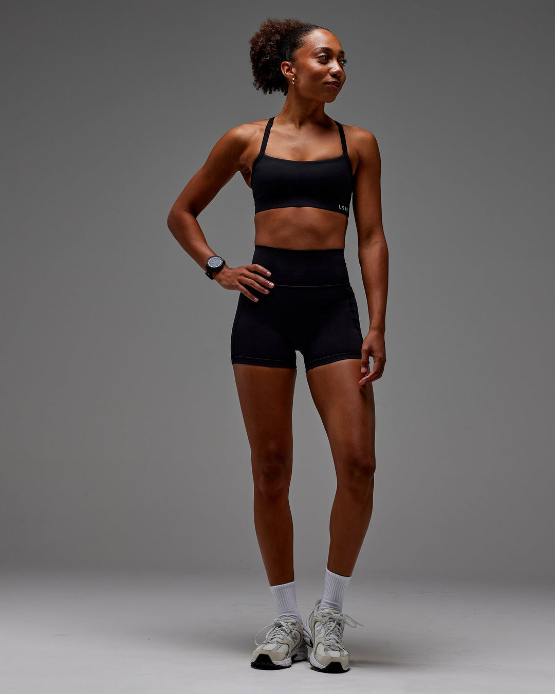 Woman wearing Fusion Ultra High-Rise 4" Short Pockets - Black | Model:Txai | Size:XS