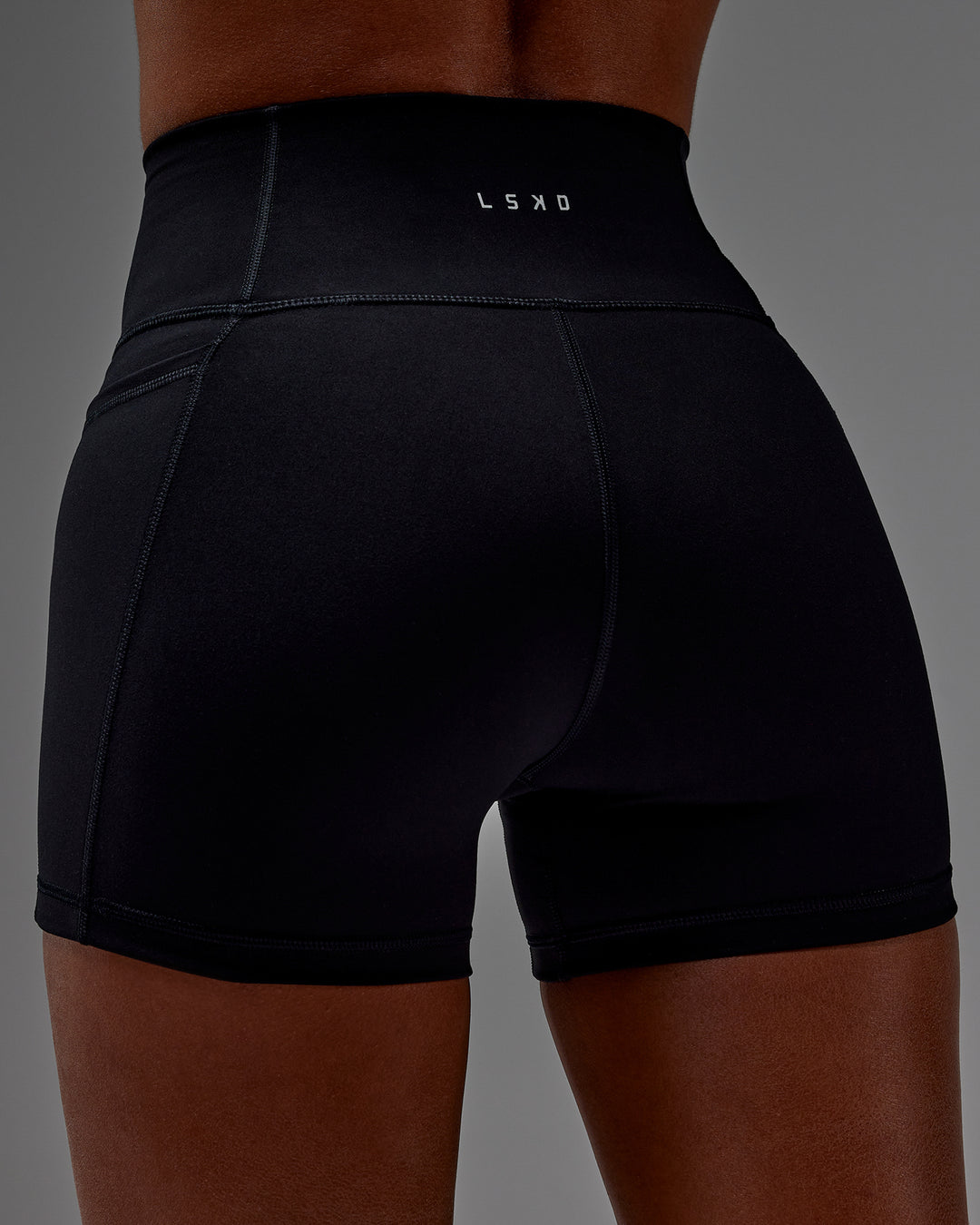 Woman wearing Fusion Ultra High-Rise 4" Short Pockets - Black | Model:Txai | Size:XS