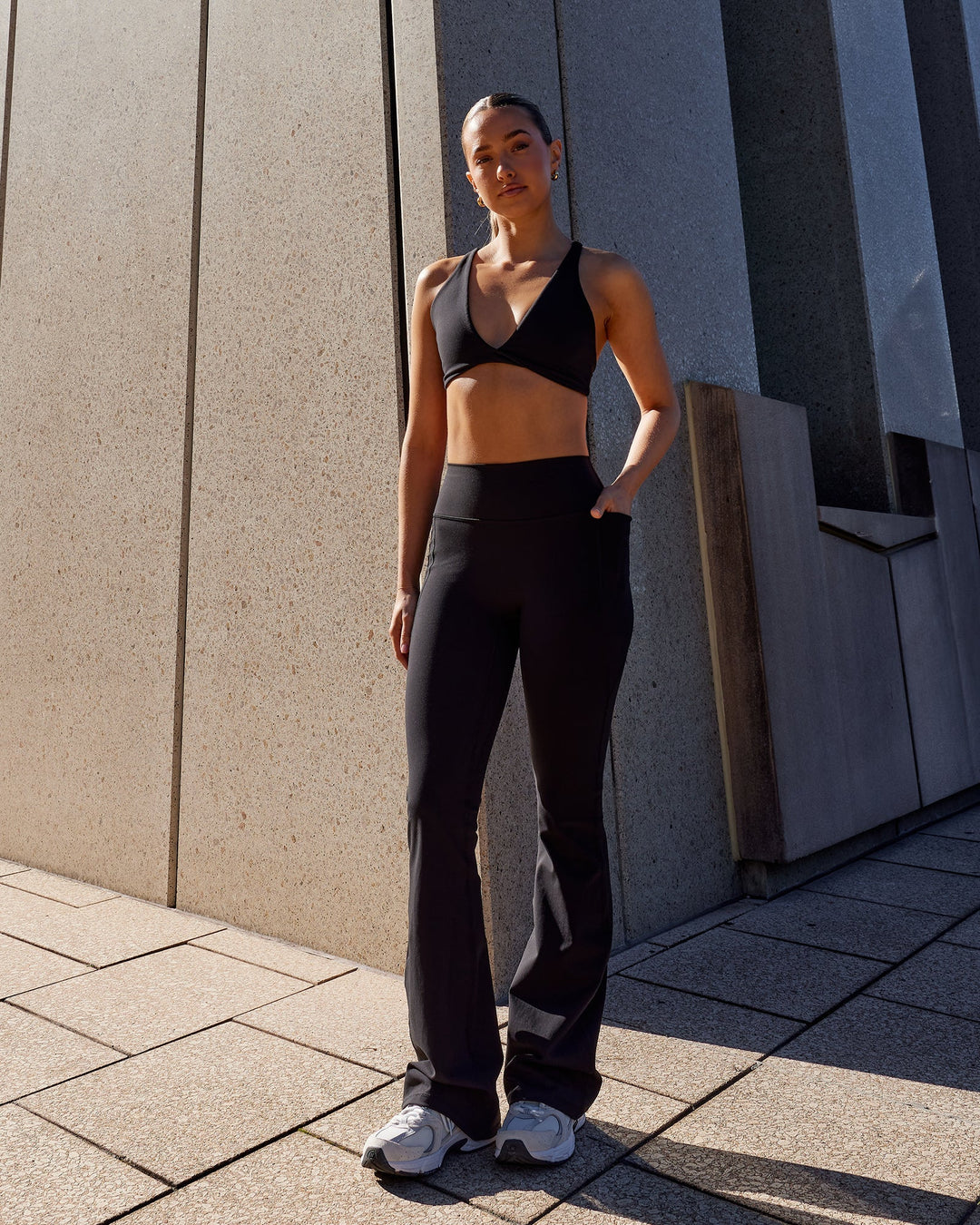 Woman wearing Fusion Ultra High-Rise Flared Legging Pockets - Black | Model:Milly | Size:S