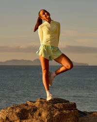 Woman wearing GG AeroFLX+ Long Sleeve Half Zip - Lemon-Baltic Sea | Model:Grace | Size:XS