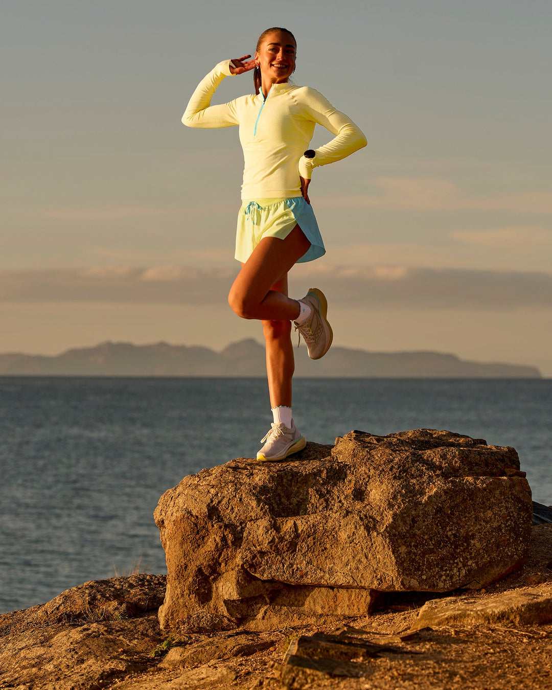 Woman wearing GG AeroFLX+ Long Sleeve Half Zip - Lemon-Baltic Sea | Model:Grace | Size:XS
