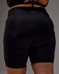 Woman wearing Fusion Ultra High-Rise 9" Short Pockets - Black | Model:Jordie | Size:2XL