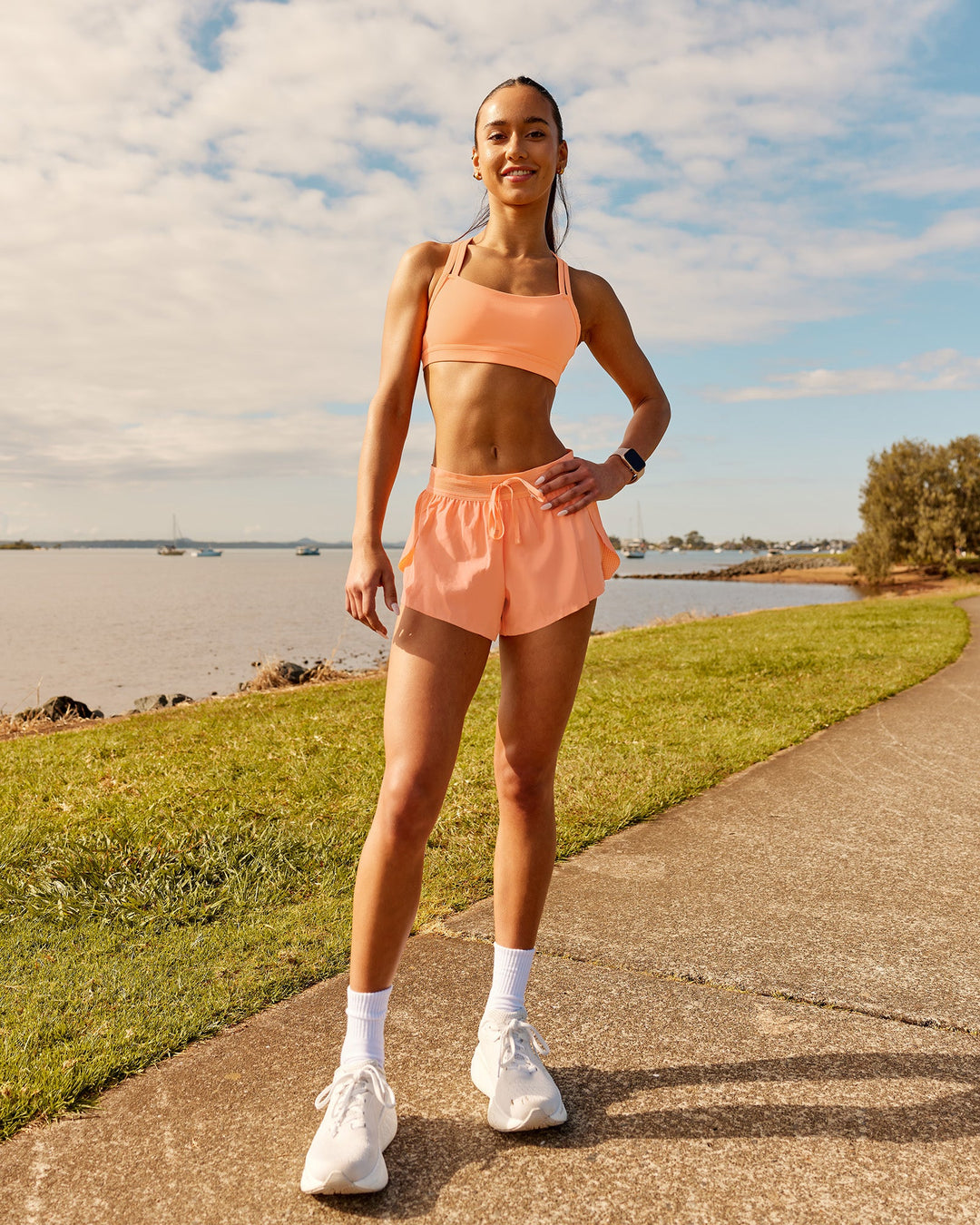 Woman wearing Velocity Sports Bra - Cantaloupe | Model:Zara | Size:2XS