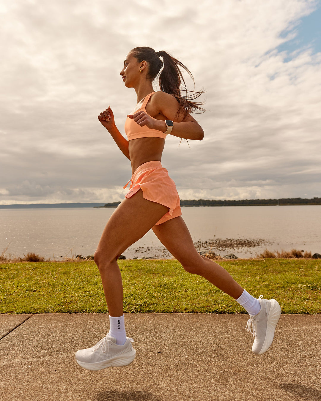 Woman wearing Velocity Sports Bra - Cantaloupe | Model:Zara | Size:2XS