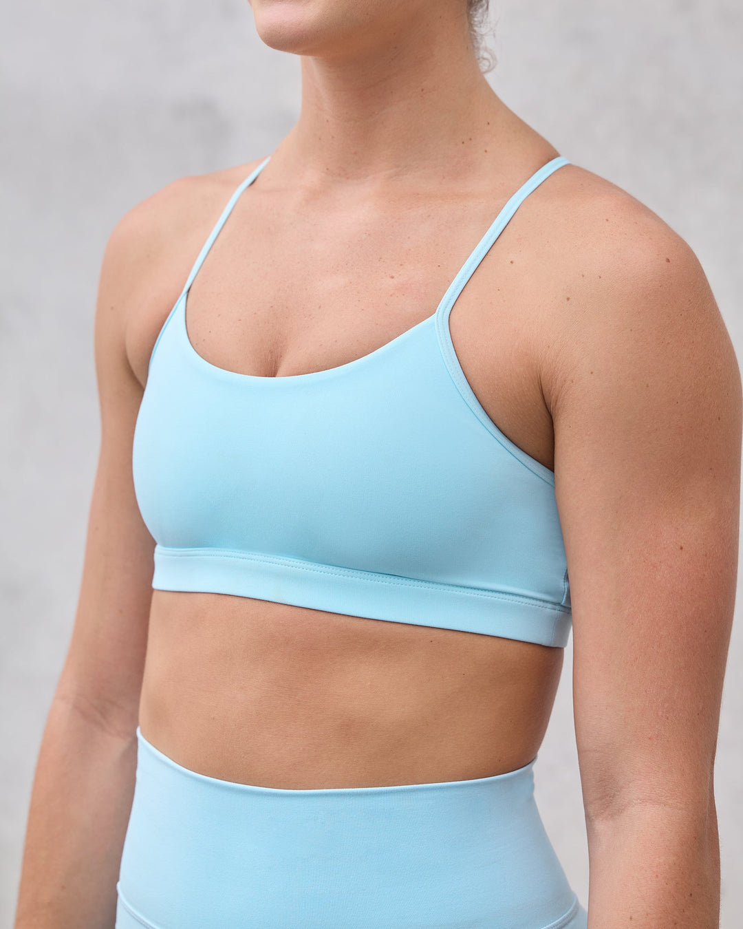 Woman wearing Glow Sports Bra - Crystal Blue