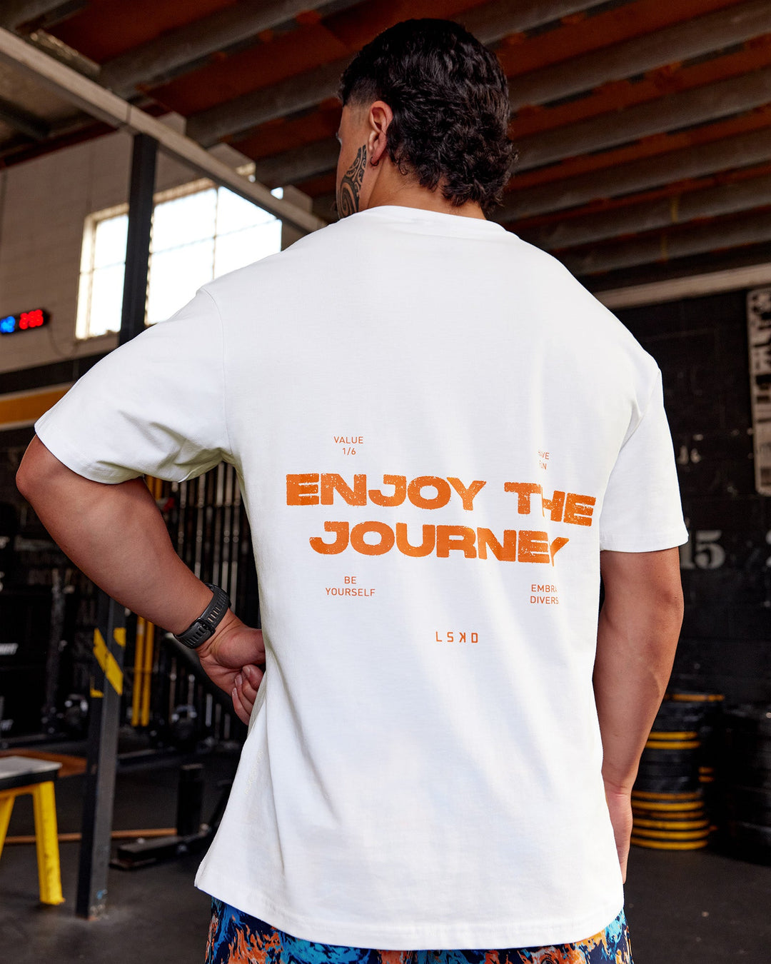 Man wearing Enjoy the Journey Value Series FLXCotton Tee Oversize - White-Vibrant Orange | Model:Hiko | Size:L