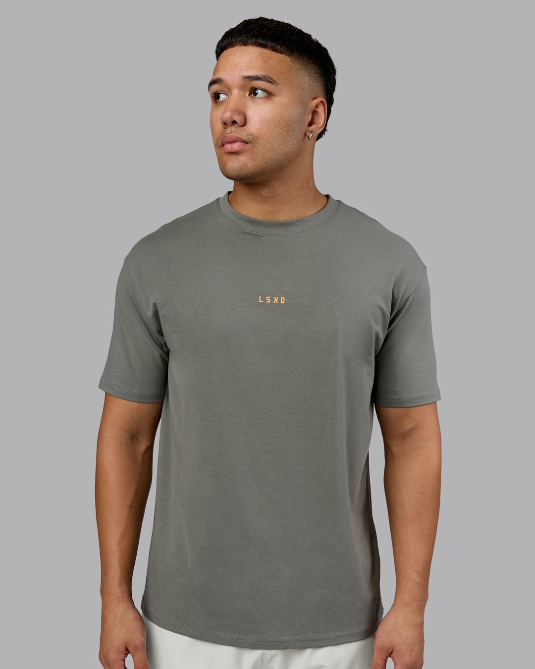 Man wearing On Repeat FLXCotton Oversized Tee - Graphite-Warm Apricot | Model:Kaelyb | Size:L