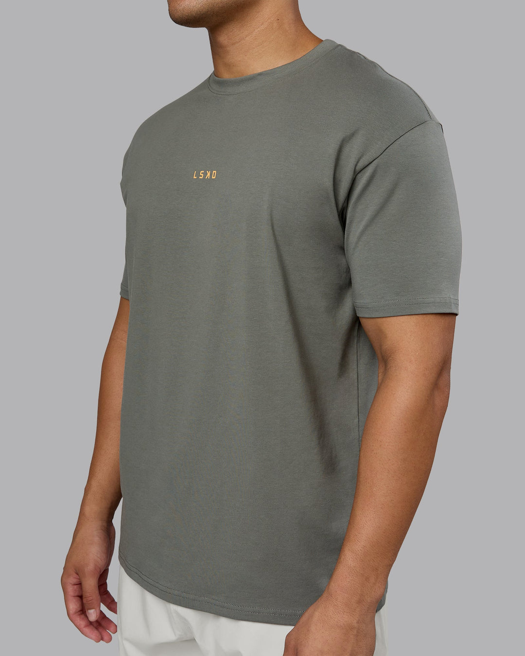 Man wearing On Repeat FLXCotton Oversized Tee - Graphite-Warm Apricot | Model:Kaelyb | Size:L
