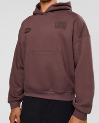 Man wearing Static Grit Unisex Boxy Hoodie - Cocoa Powder-Hot Chocolate | Model:Jackson | Size:L