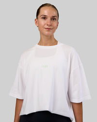 Woman wearing Together We Rise FLXCotton Oversized Tee - White-Solar Lime | Model:Myrte | Size:L