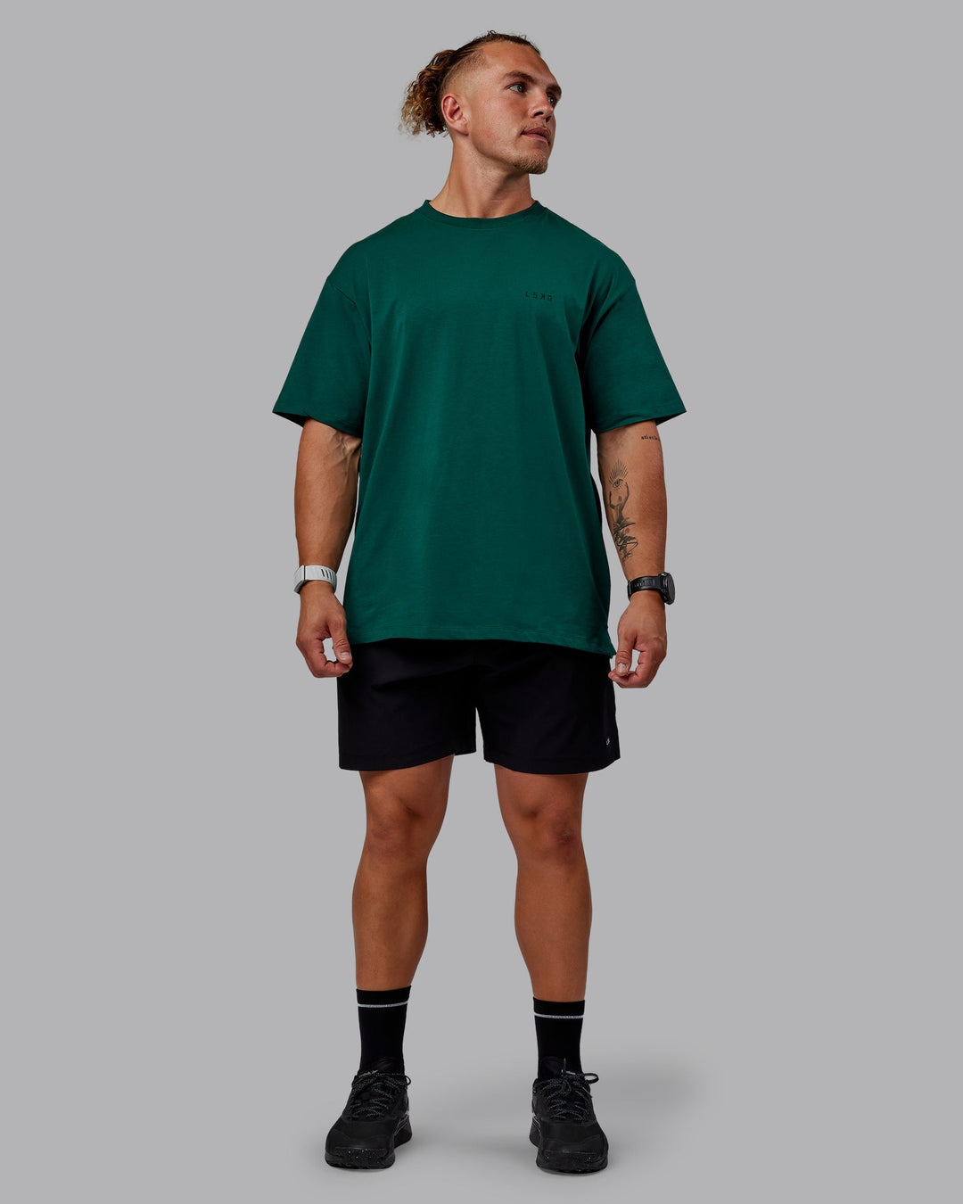 Man wearing Unisex Deluxe PimaFLX Tee Oversize - Deep Emerald