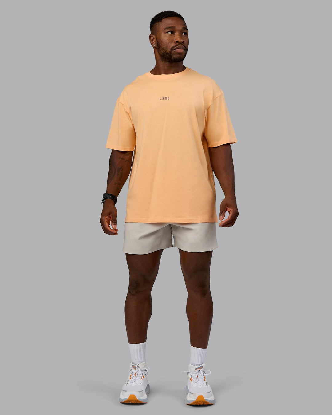 Man wearing On Repeat FLXCotton Oversized Tee - Peach Fuzz-White | Model:Sam | Size:L
