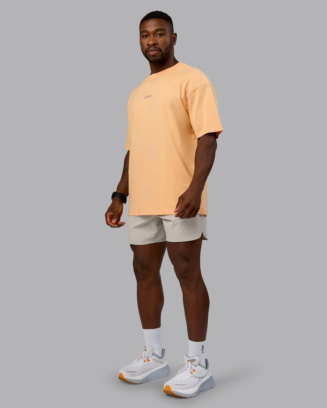 Man wearing On Repeat FLXCotton Oversized Tee - Peach Fuzz-White | Model:Sam | Size:L