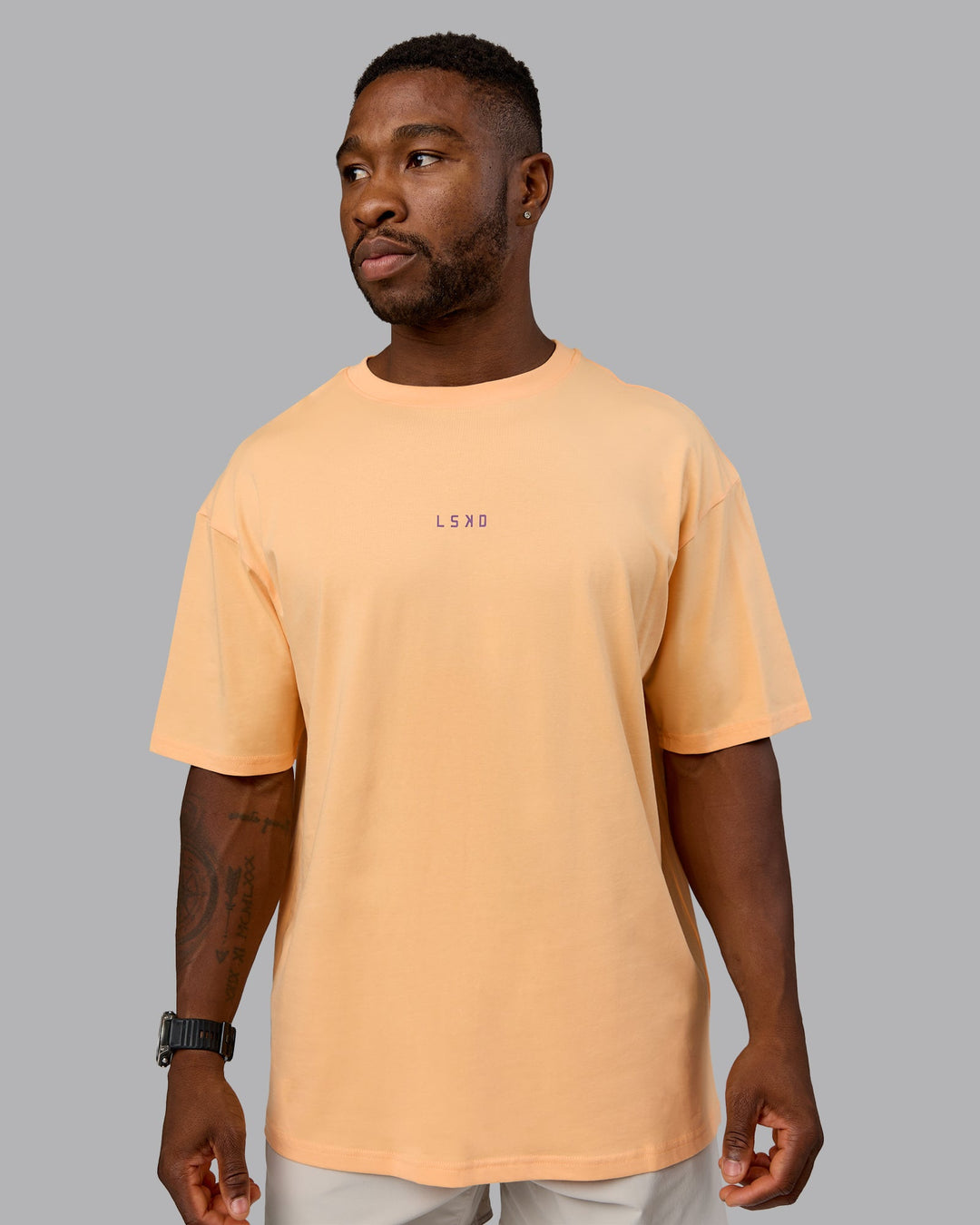 Man wearing On Repeat FLXCotton Oversized Tee - Peach Fuzz-White | Model:Sam | Size:L