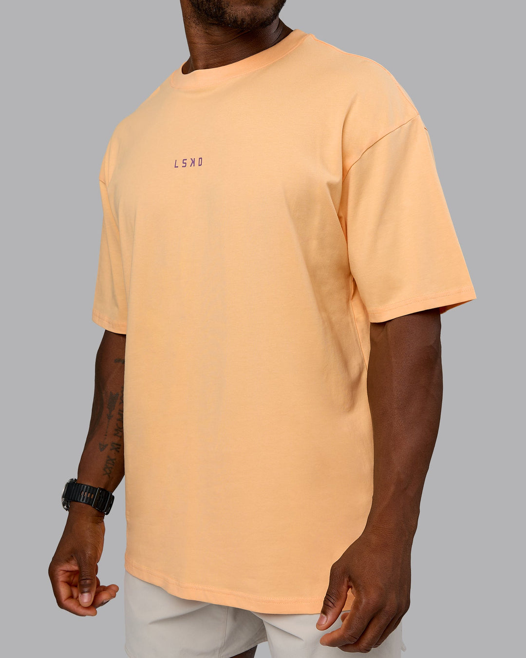Man wearing On Repeat FLXCotton Oversized Tee - Peach Fuzz-White | Model:Sam | Size:L