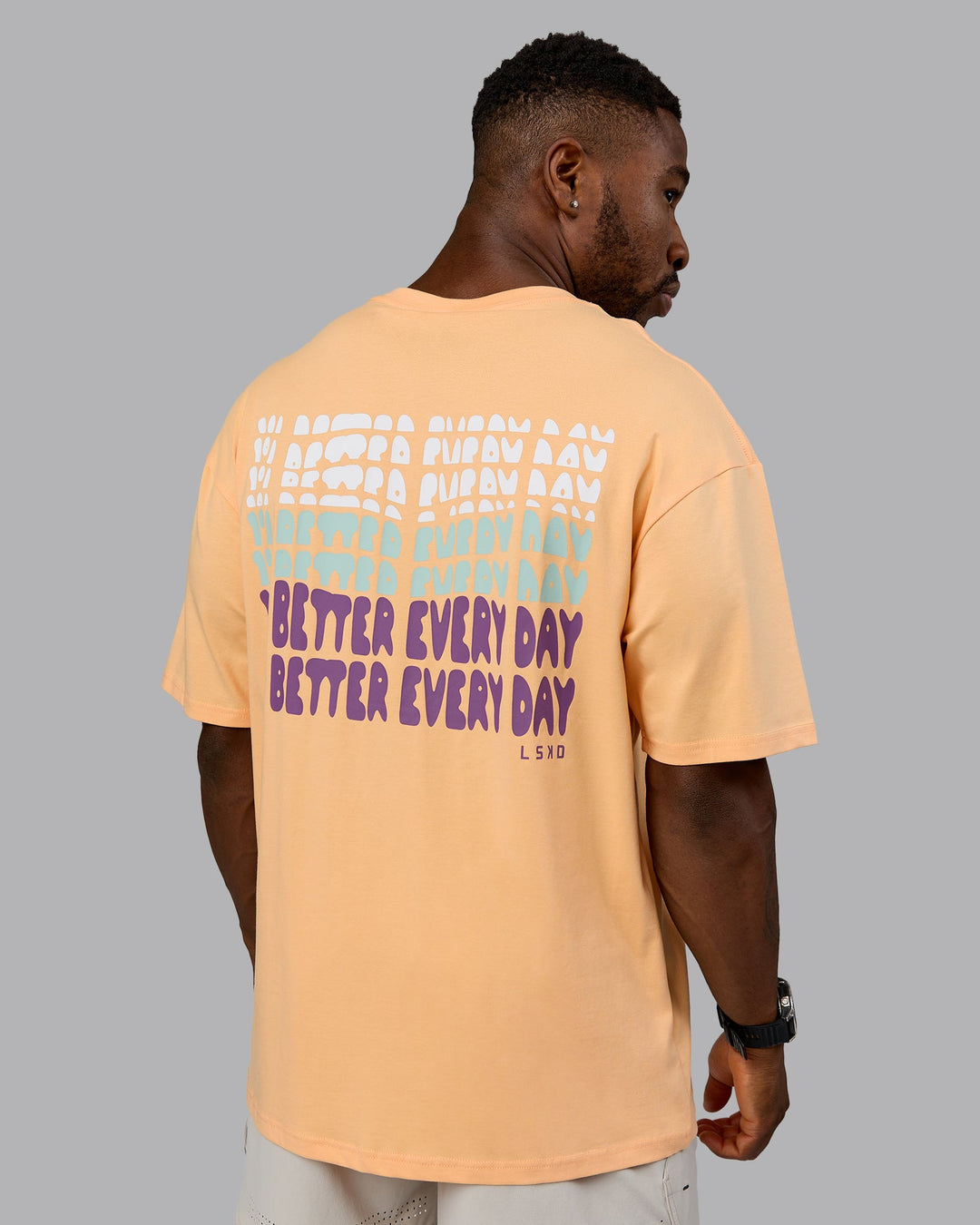 Man wearing On Repeat FLXCotton Oversized Tee - Peach Fuzz-White | Model:Sam | Size:L