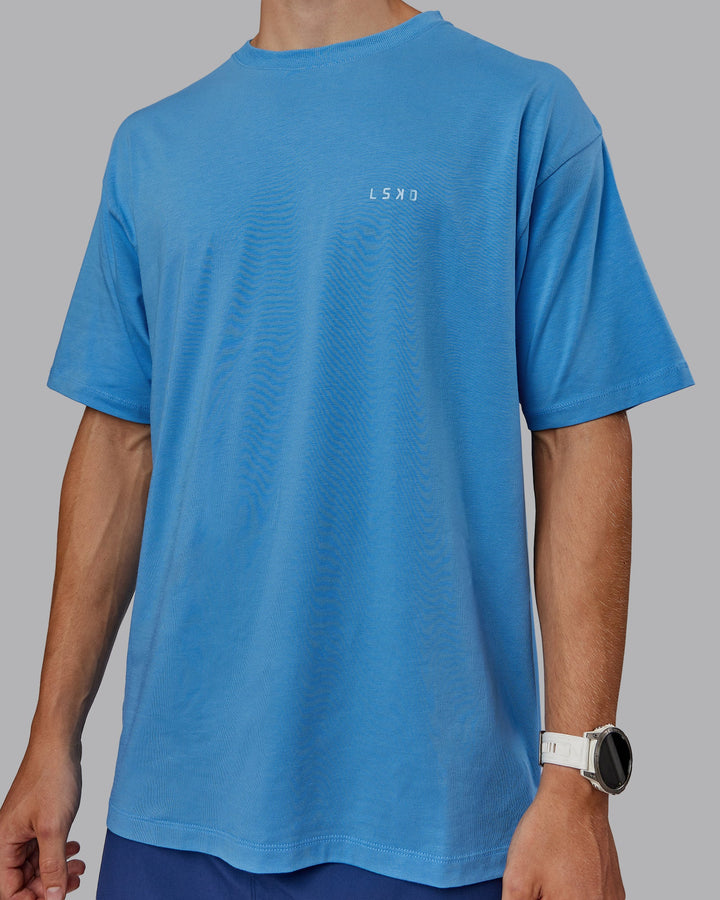 Man wearing Unisex PimaFLX Tee Oversize in Azure Blue | Size:L
