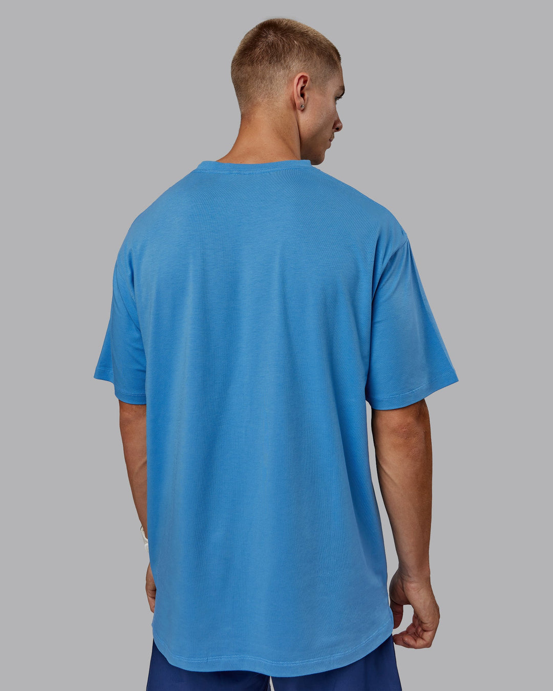 Man wearing Unisex PimaFLX Tee Oversize in Azure Blue | Size:L