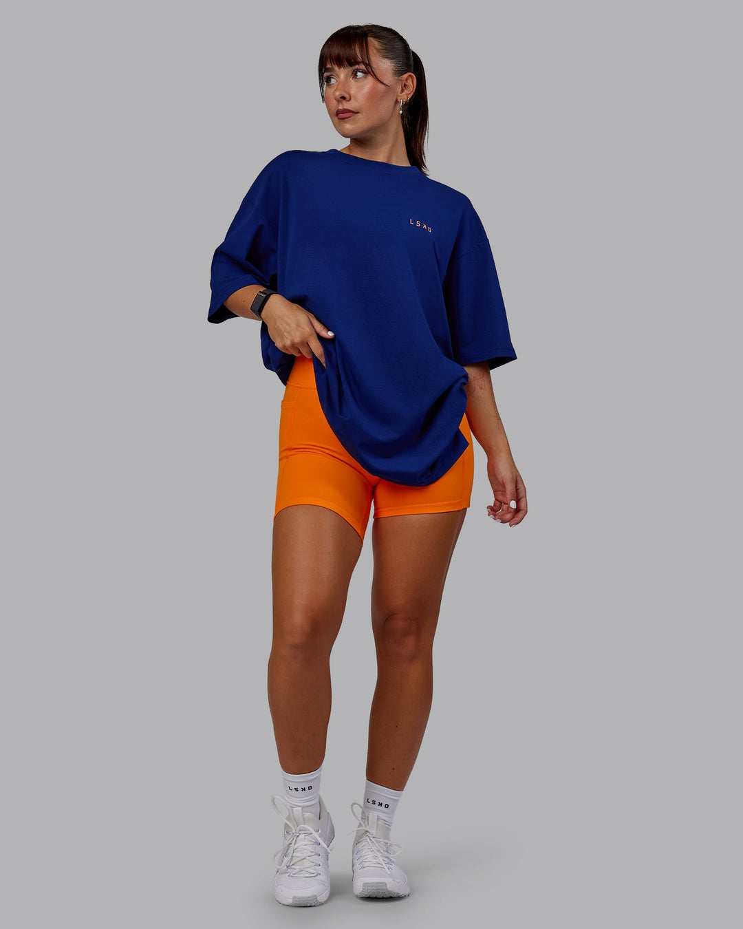 Woman wearing Unisex Strike Through FLXCotton Tee Oversize - Midnight Blue-Vibrant Orange