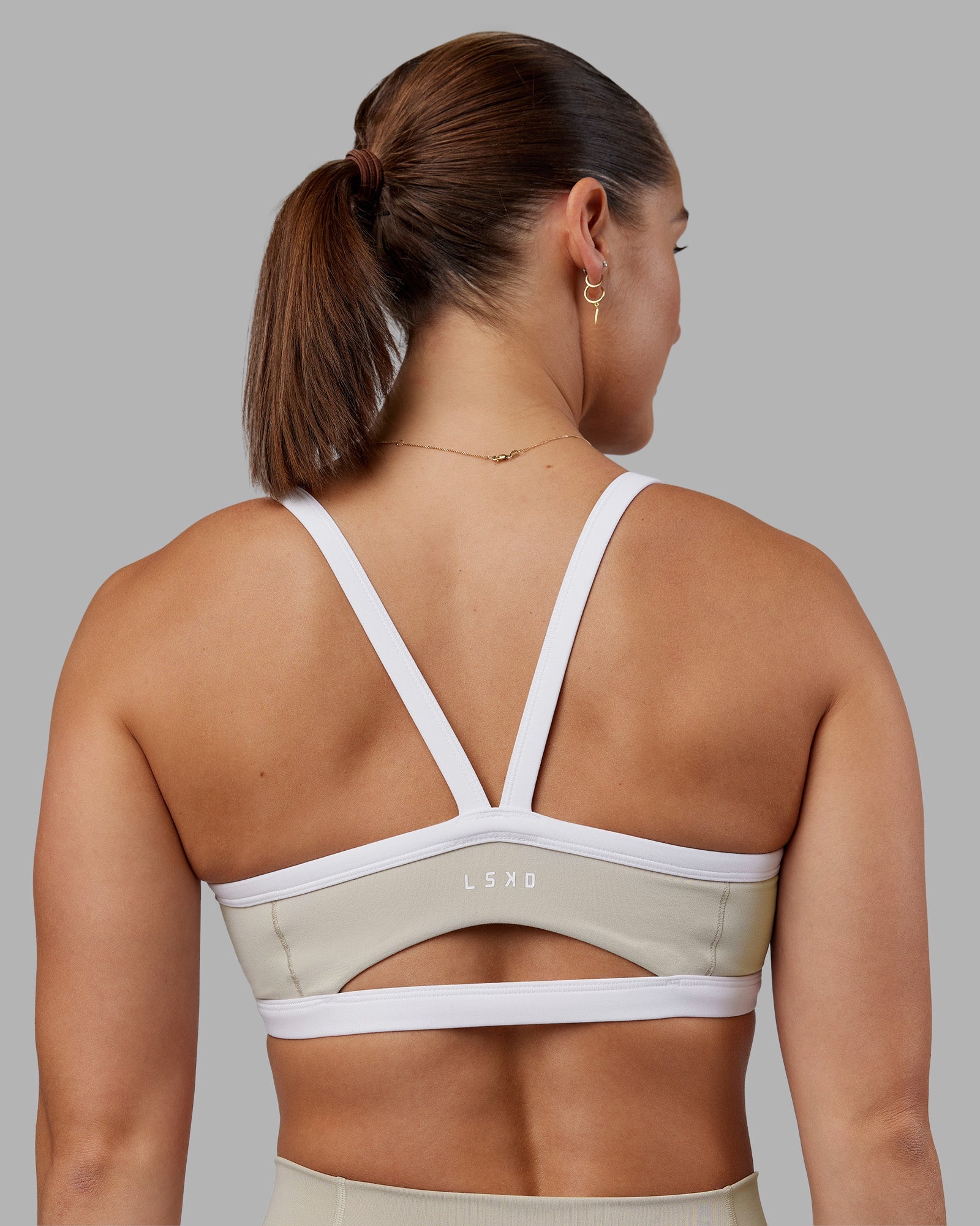 Woman wearing Abs Ignite Sports Bra - Shale Beige-White | Model:Abbey | Size:M