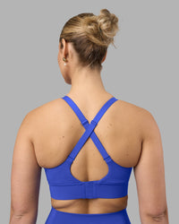 Woman wearing Accelerate Sports Bra - Power Cobalt | Set:true | Angle:back | Model:Amy | Size:M