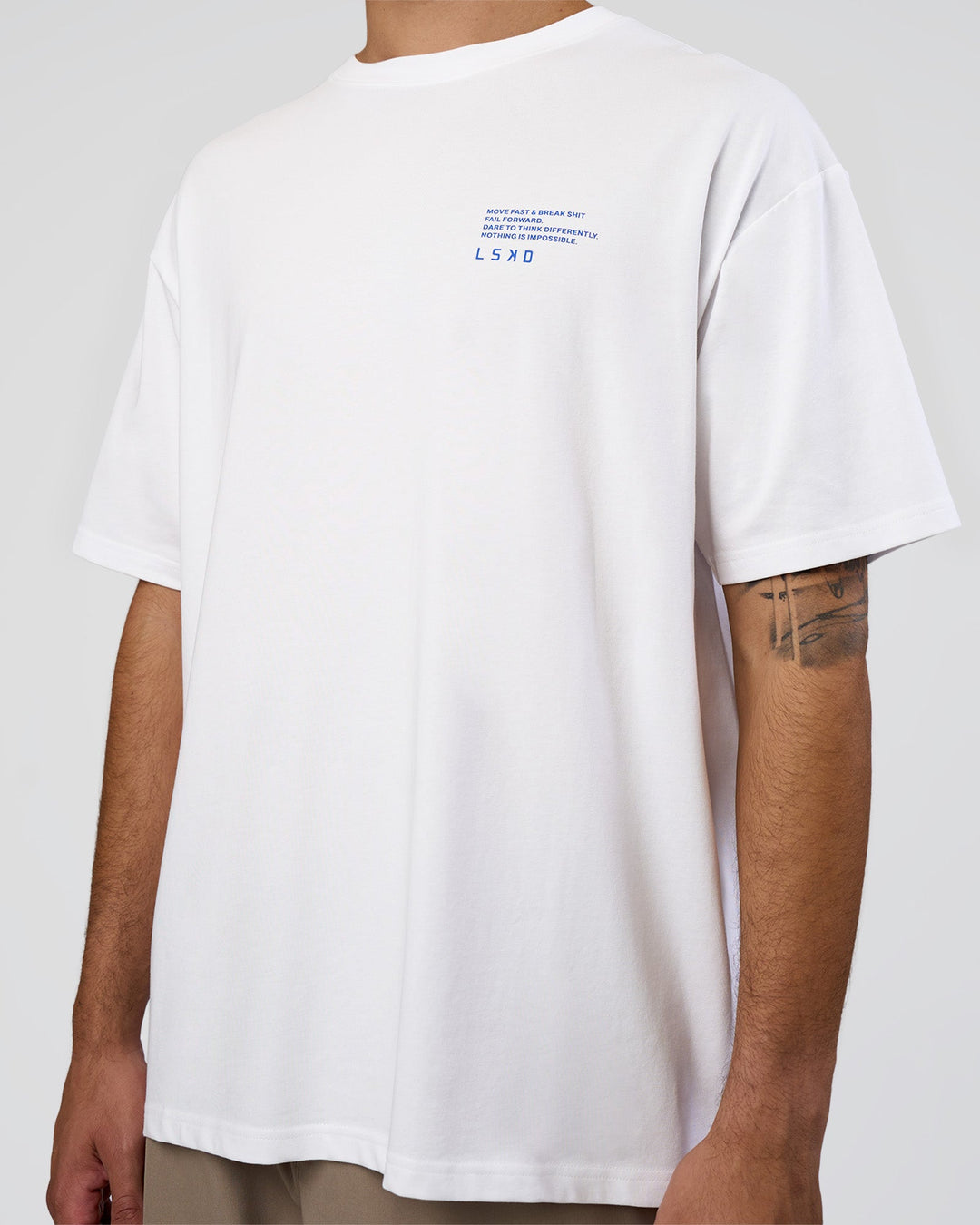 Man wearing Coffee Run FLXCotton Oversized Tee - White-Electric Indigo | Model:Zoran | Size:L