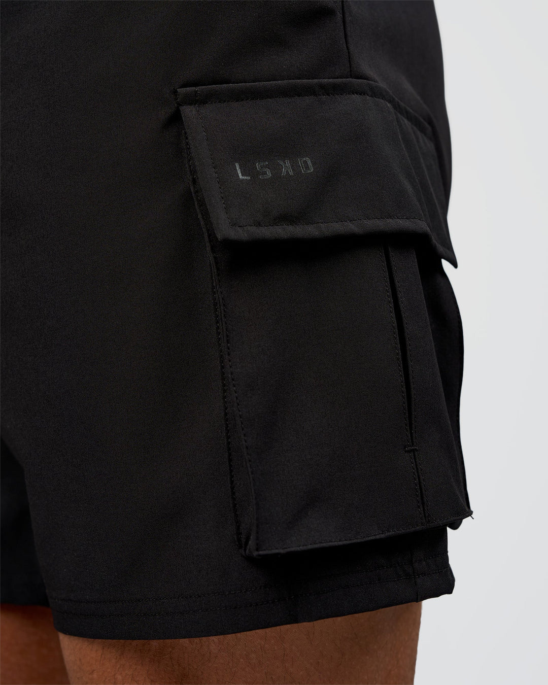 Man wearing Energy Stretch 6" Performance Cargo Short - Black | Model:Daarian | Size:M