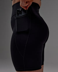 Woman wearing Fusion Ultra High-Rise 9" Short Pockets - Black | Model:Caity | Size:M