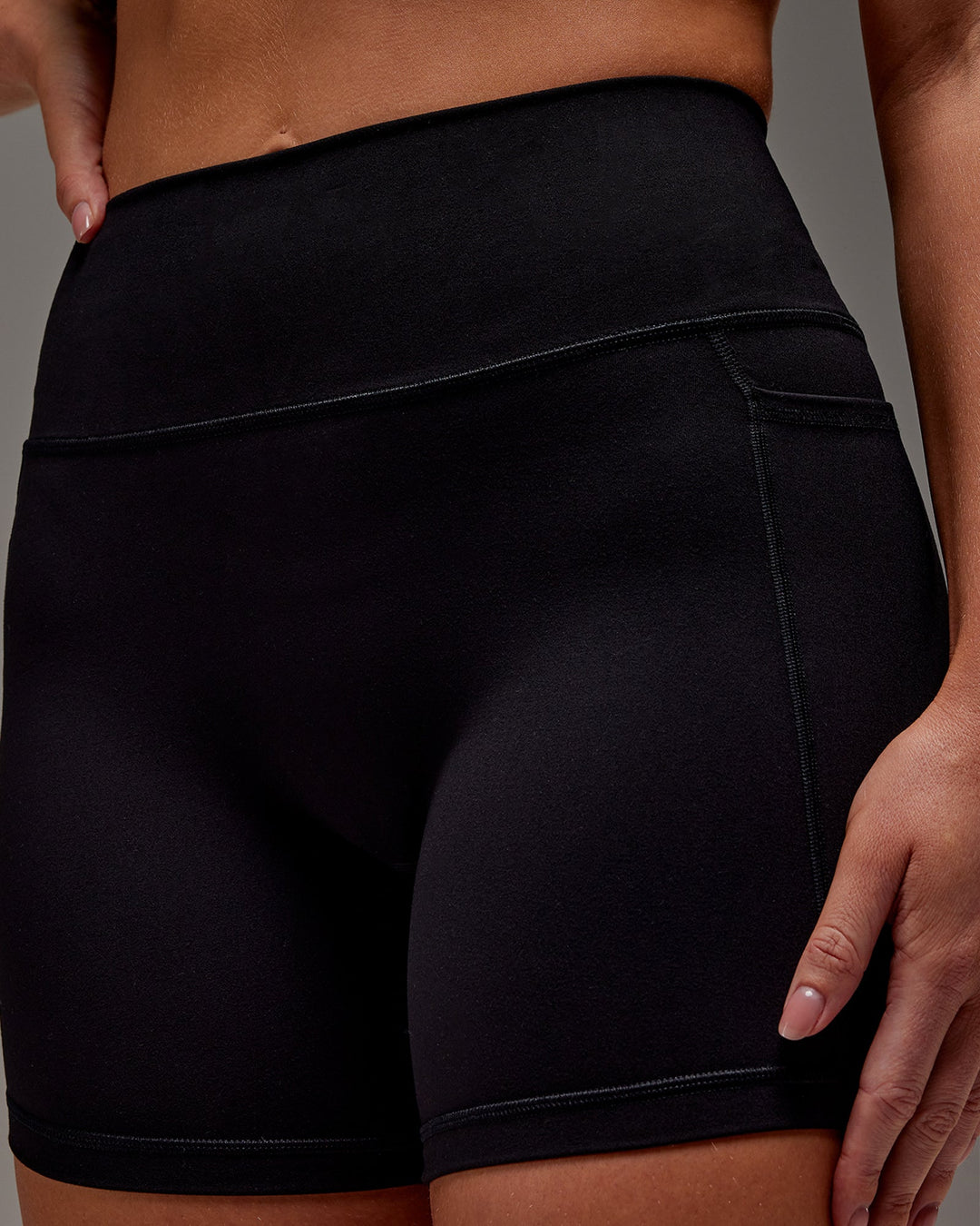 Woman wearing Fusion Mid Short Tight With Pockets in Black | Size:M