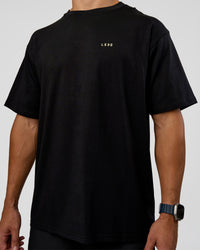 Man wearing High Run FLXCotton Oversized Tee - Black-Yellow Fizz | Model:Jaiden | Size:M