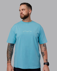 Man wearing Just Run FLXCotton Oversized Tee - Retro Blue-Light Retro Blue | Model:Macca | Size:M